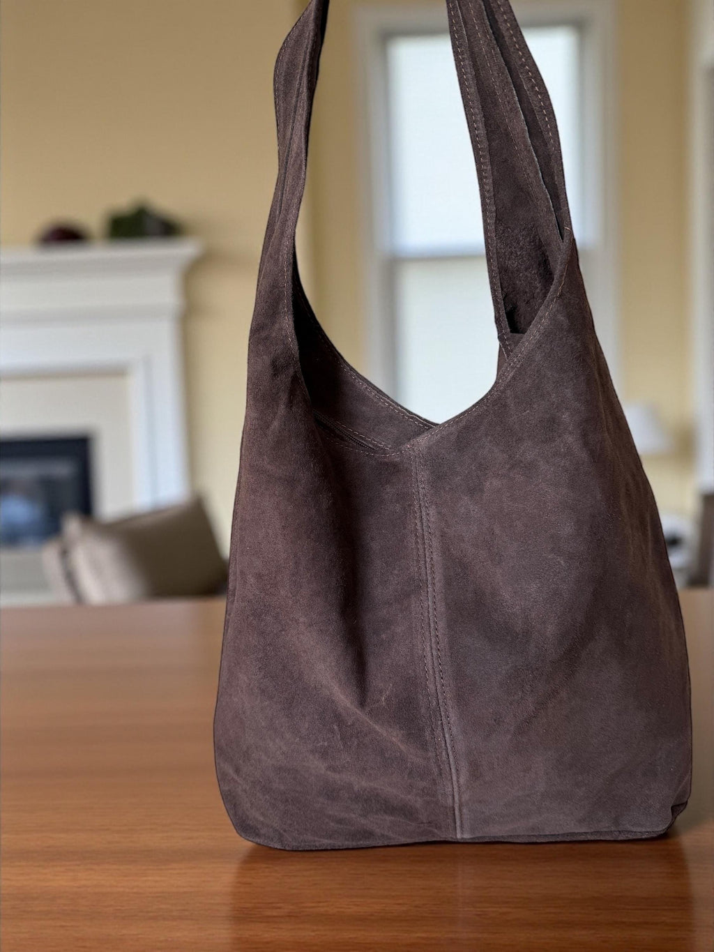 Deep V-cut opening on a large unstructured suede shoulder bag