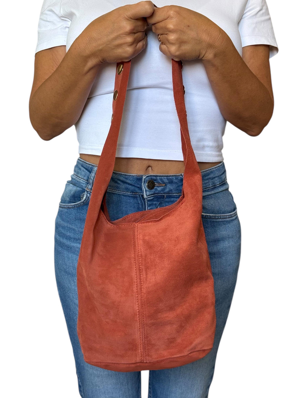 Smooth back panel of a terracotta suede studded handbag