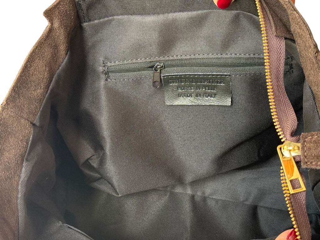 Inside view of a zippered suede tote with fabric lining and pocket