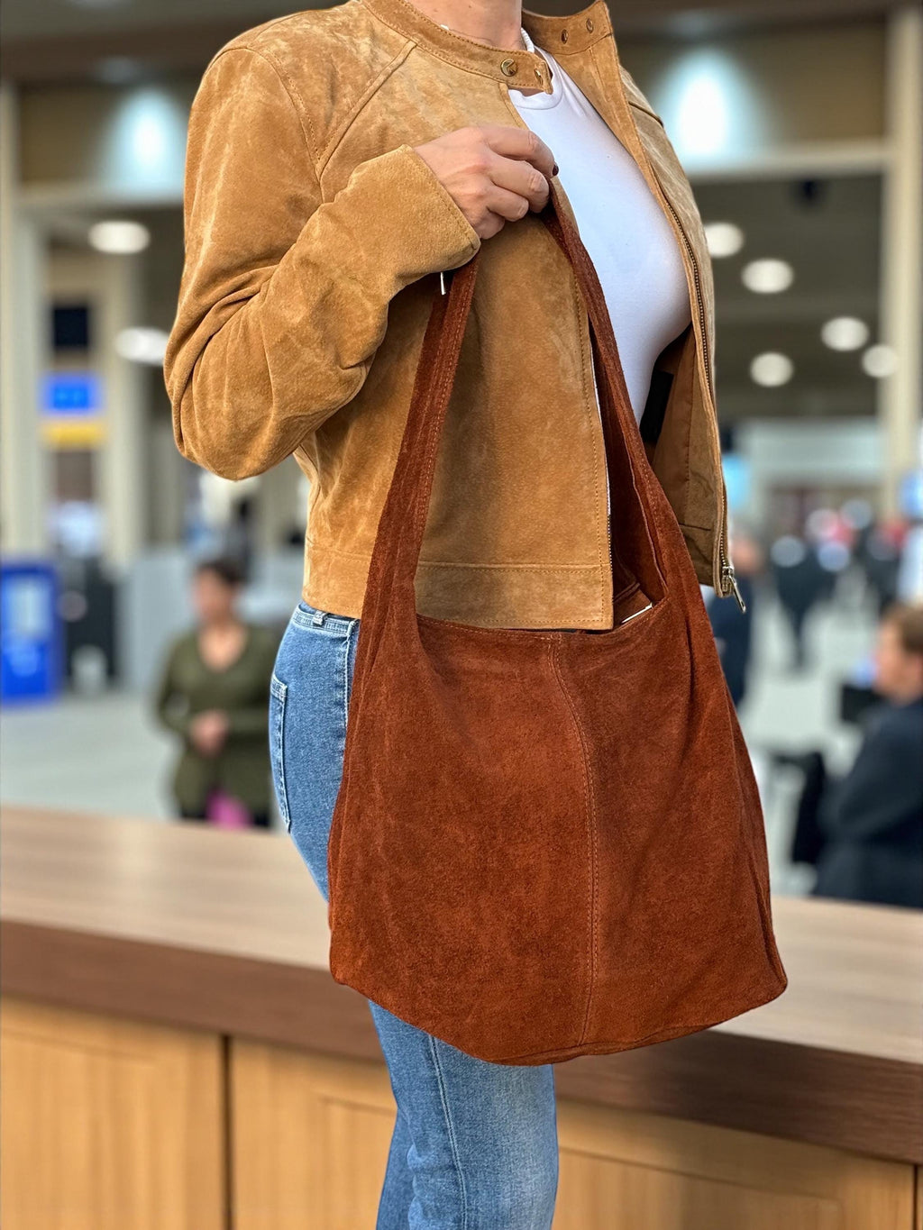 Close-up of visible stitching and wide suede shoulder strap detail
