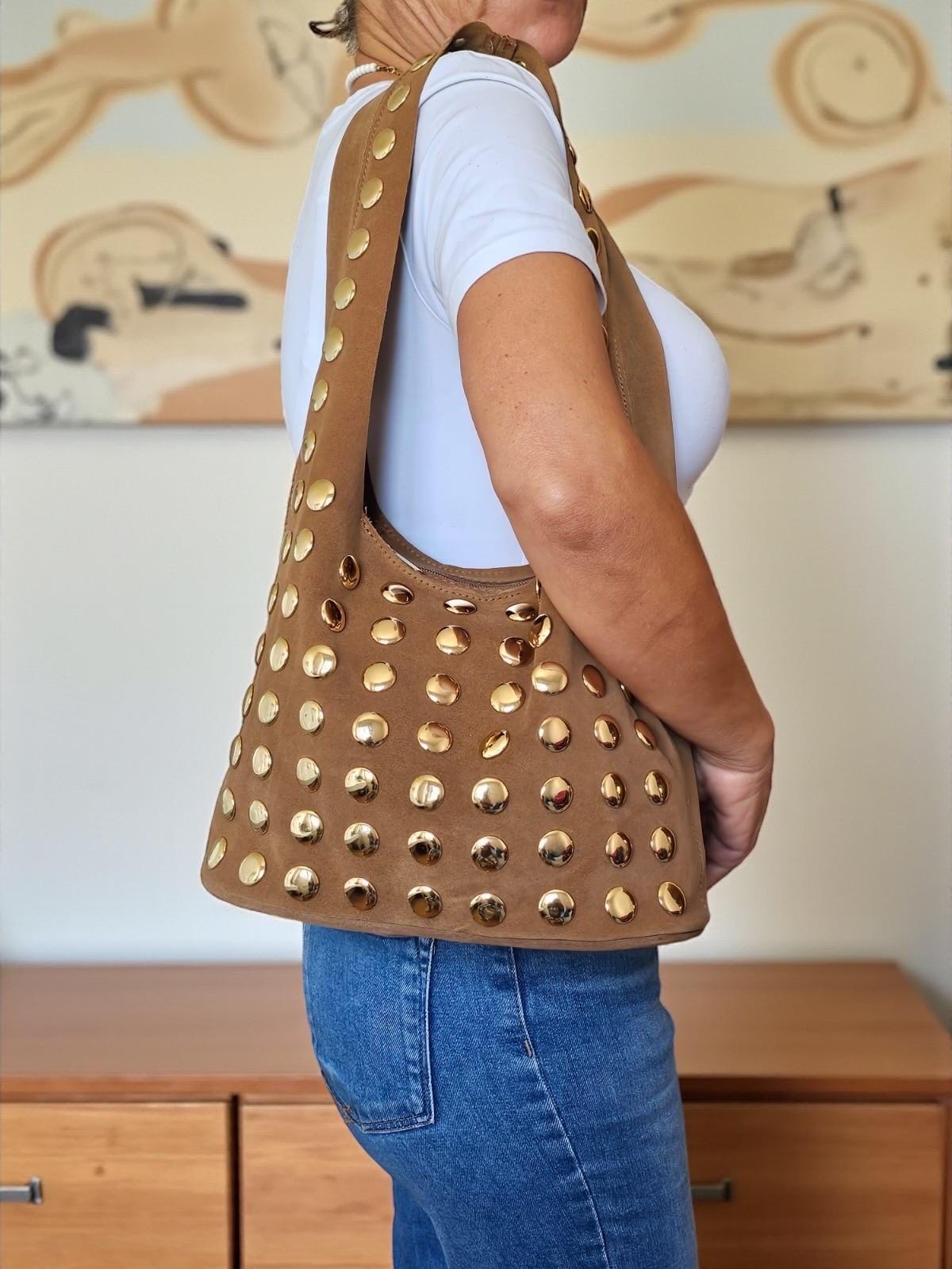 Wide suede shoulder strap and secure top zipper closure detail