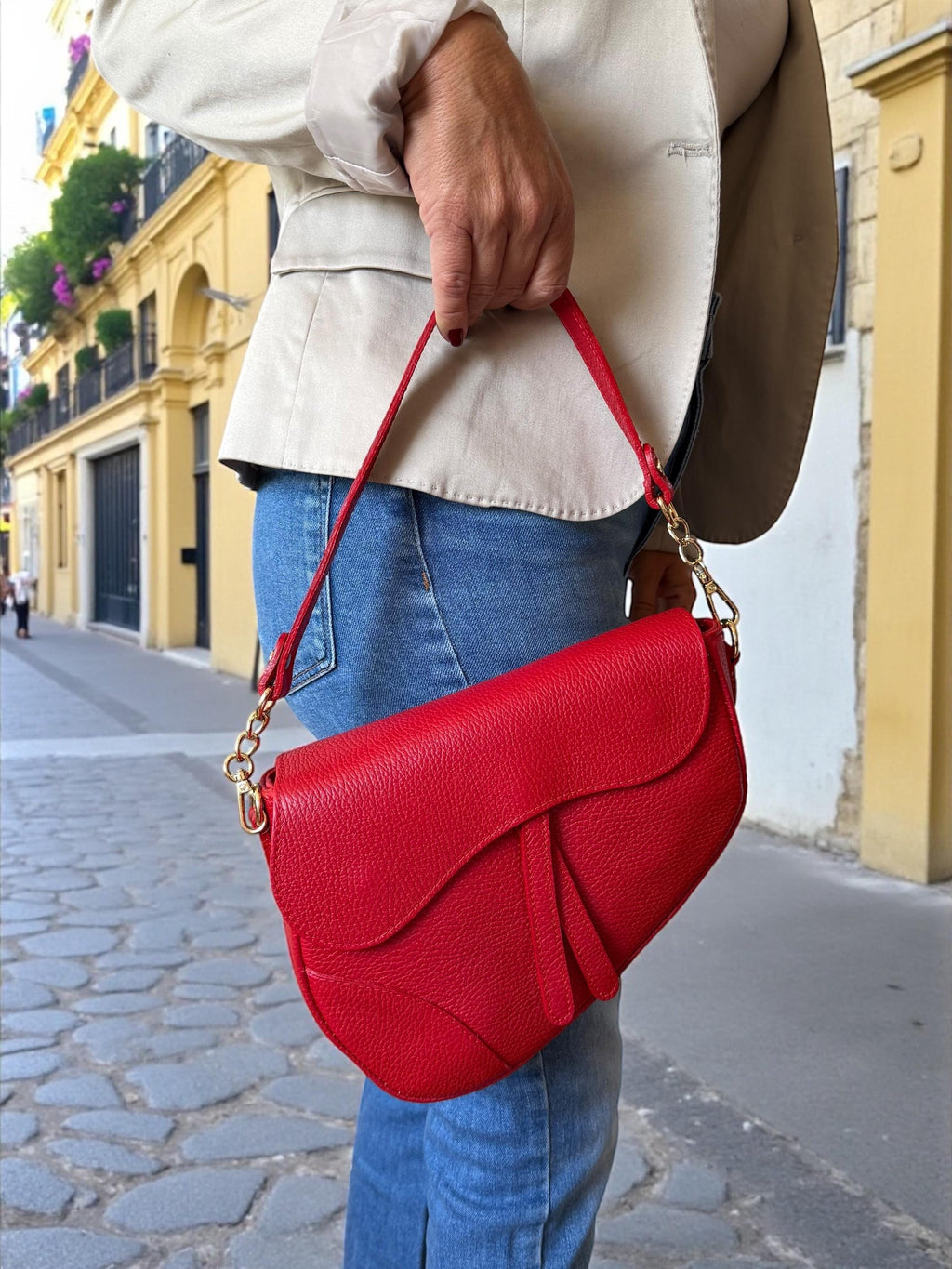 Asymmetric leather handbag with hand-carry handle and adjustable crossbody strap