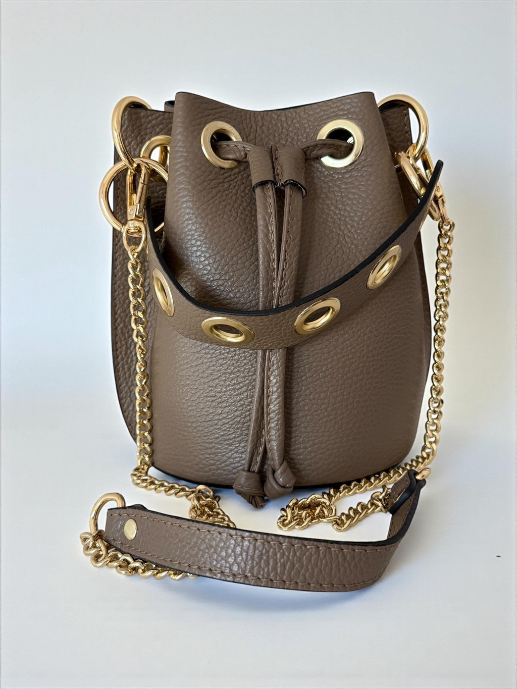 Small bucket bag with short leather handle and gold chain strap. Paloma Palomo