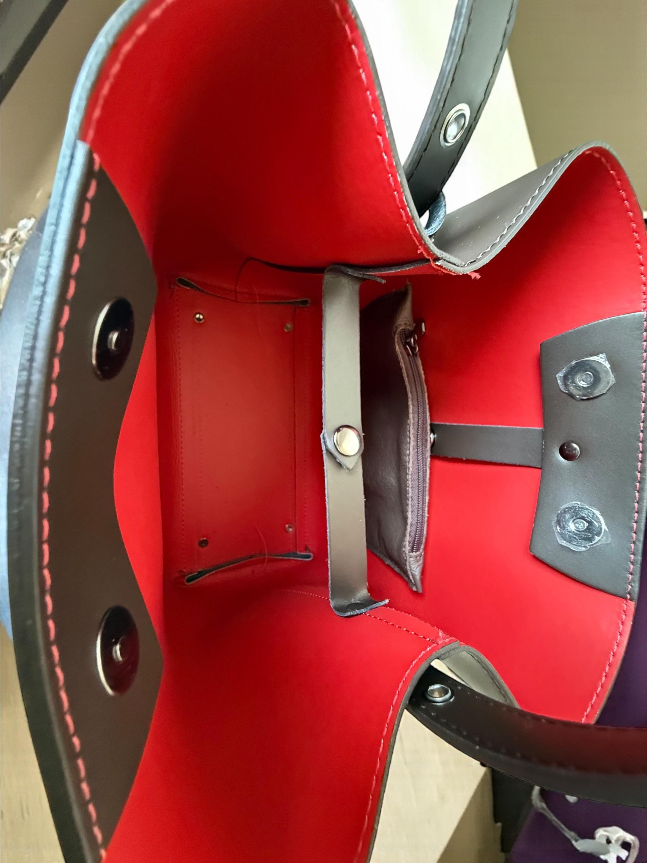 Vibrant red leather lining inside a navy blue shopper bag