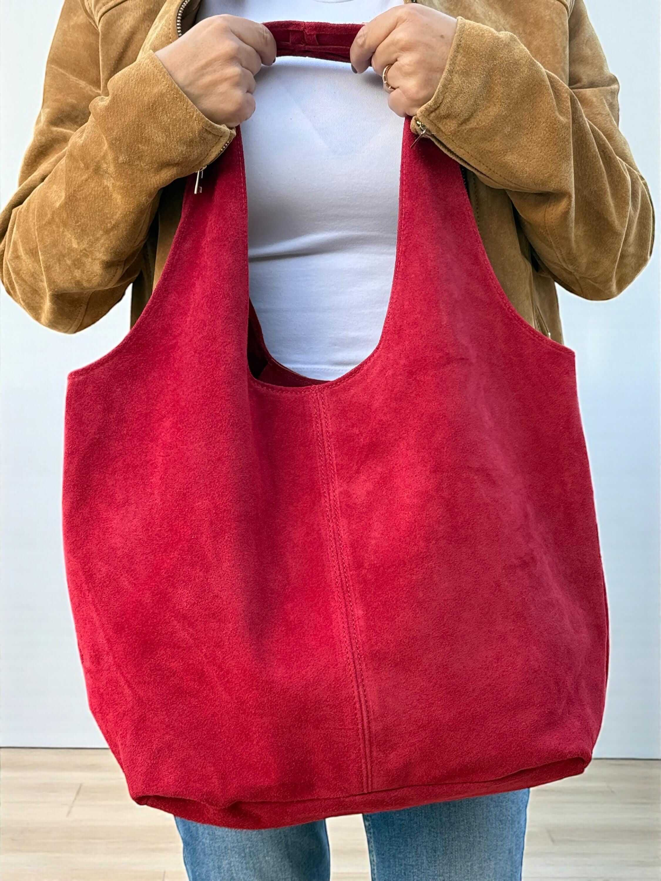 Oversized Red Suede boho Tote bag – University or office bag held by a person, showcasing its spacious and bold design.
