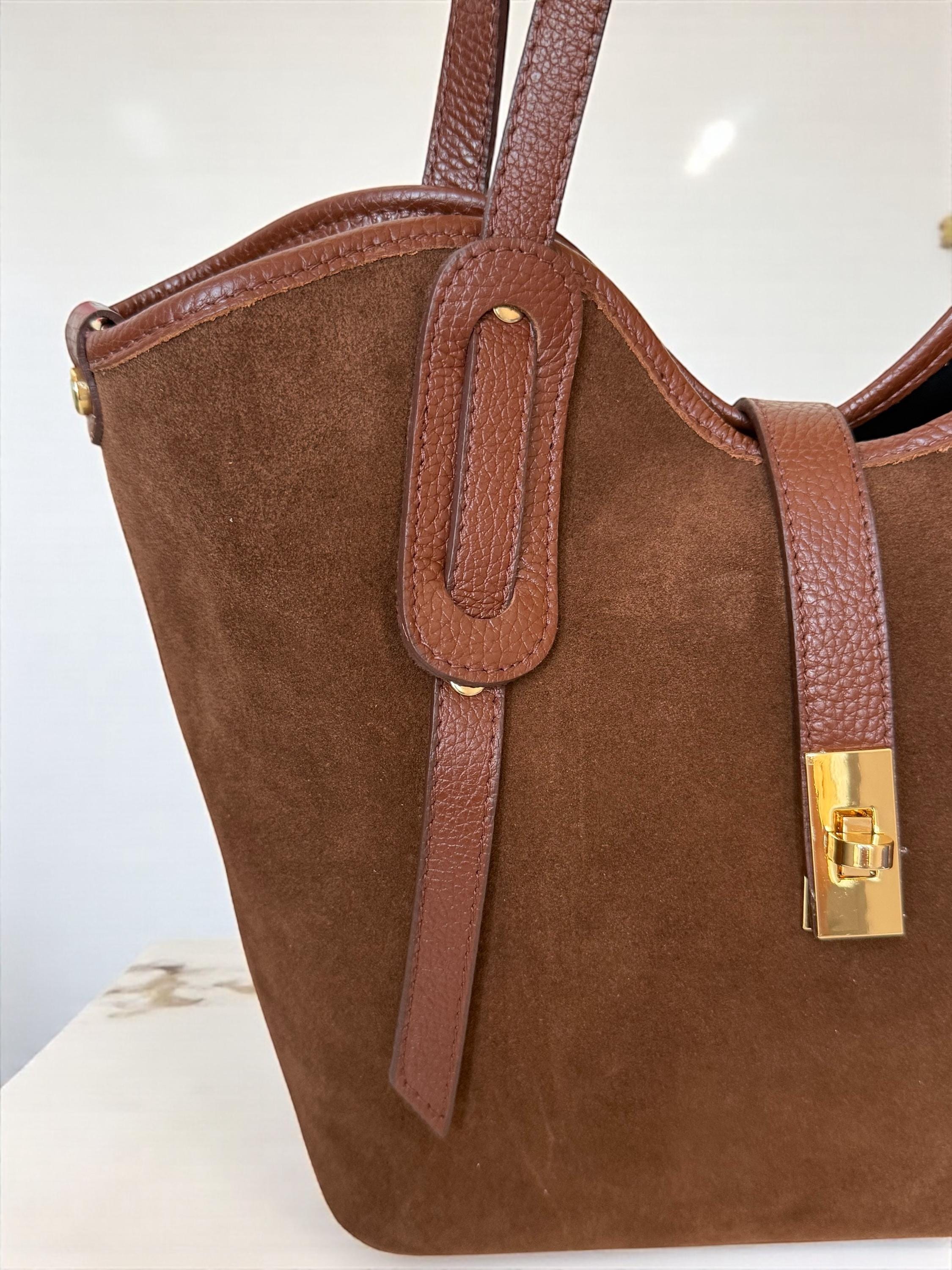 Gold-tone hardware and decorative strap closure on a Camel brown tote
