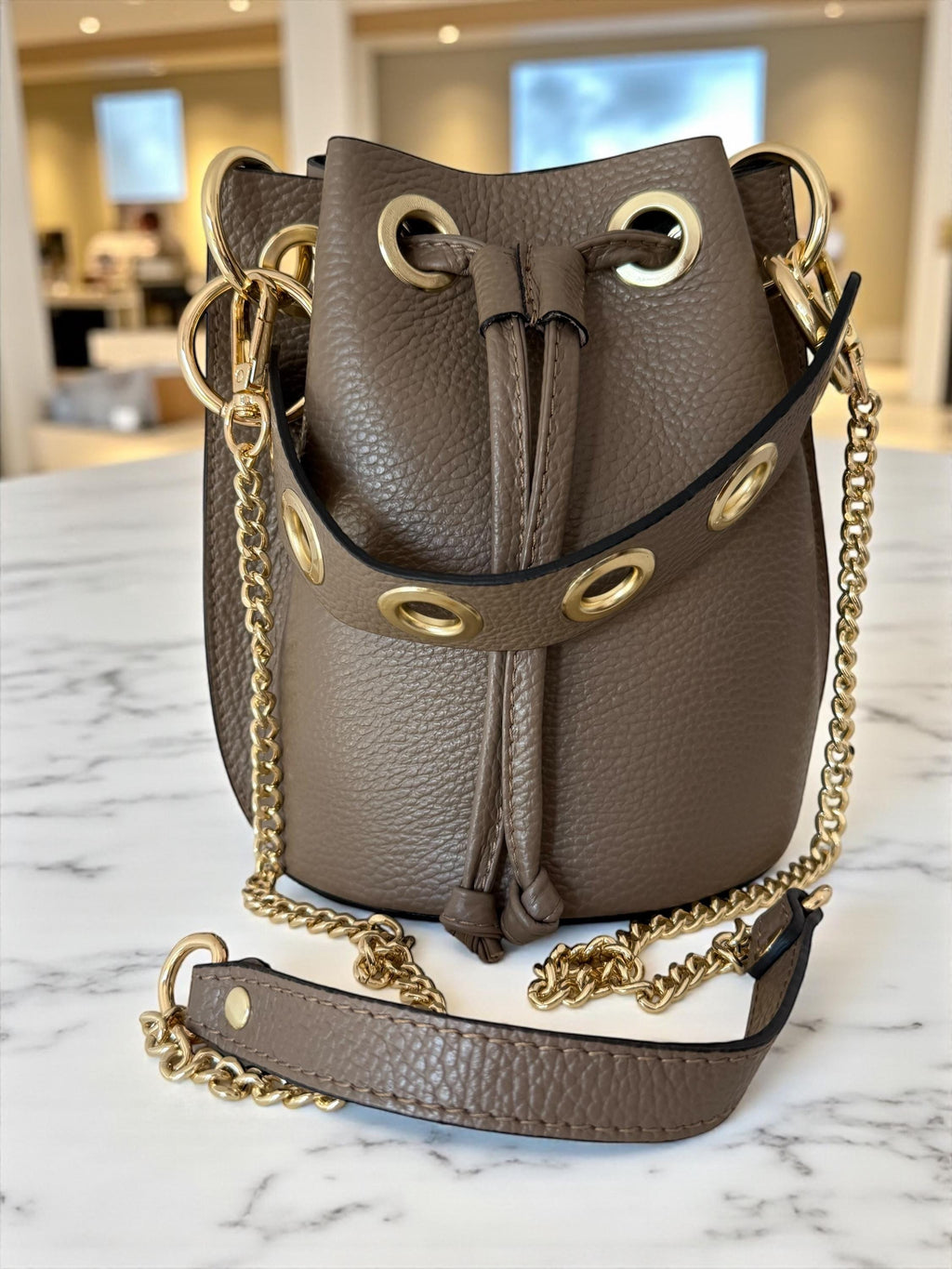 Close-up of gold eyelets and leather drawstring closure detail
