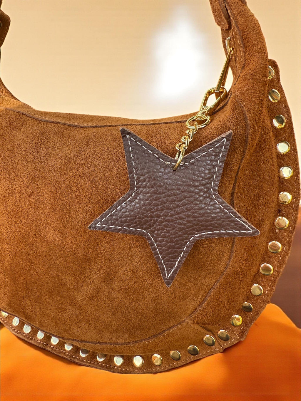 Star leather charm attached to a luxury tote bag