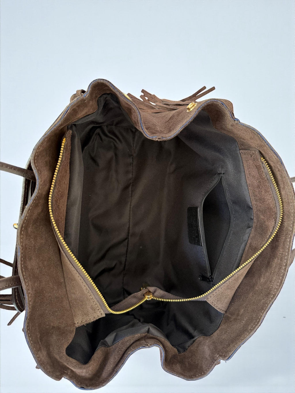 Inside view of a suede tote with fabric lining and zipper pocket