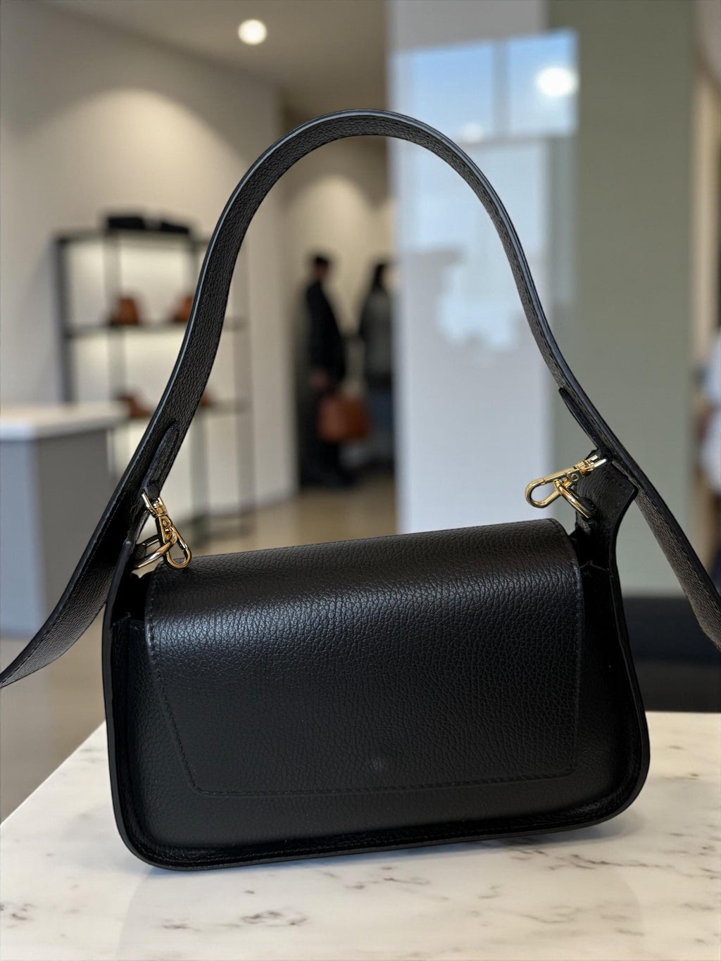 Black structured saddle flap bag in Italian pebbled leather