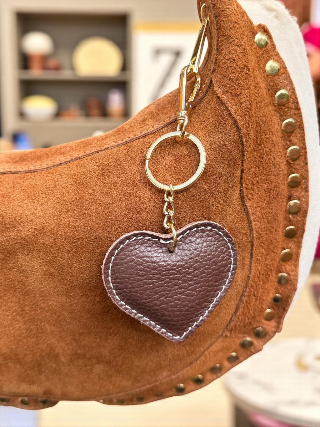 Leather heart charm styled on a large suede hobo bag