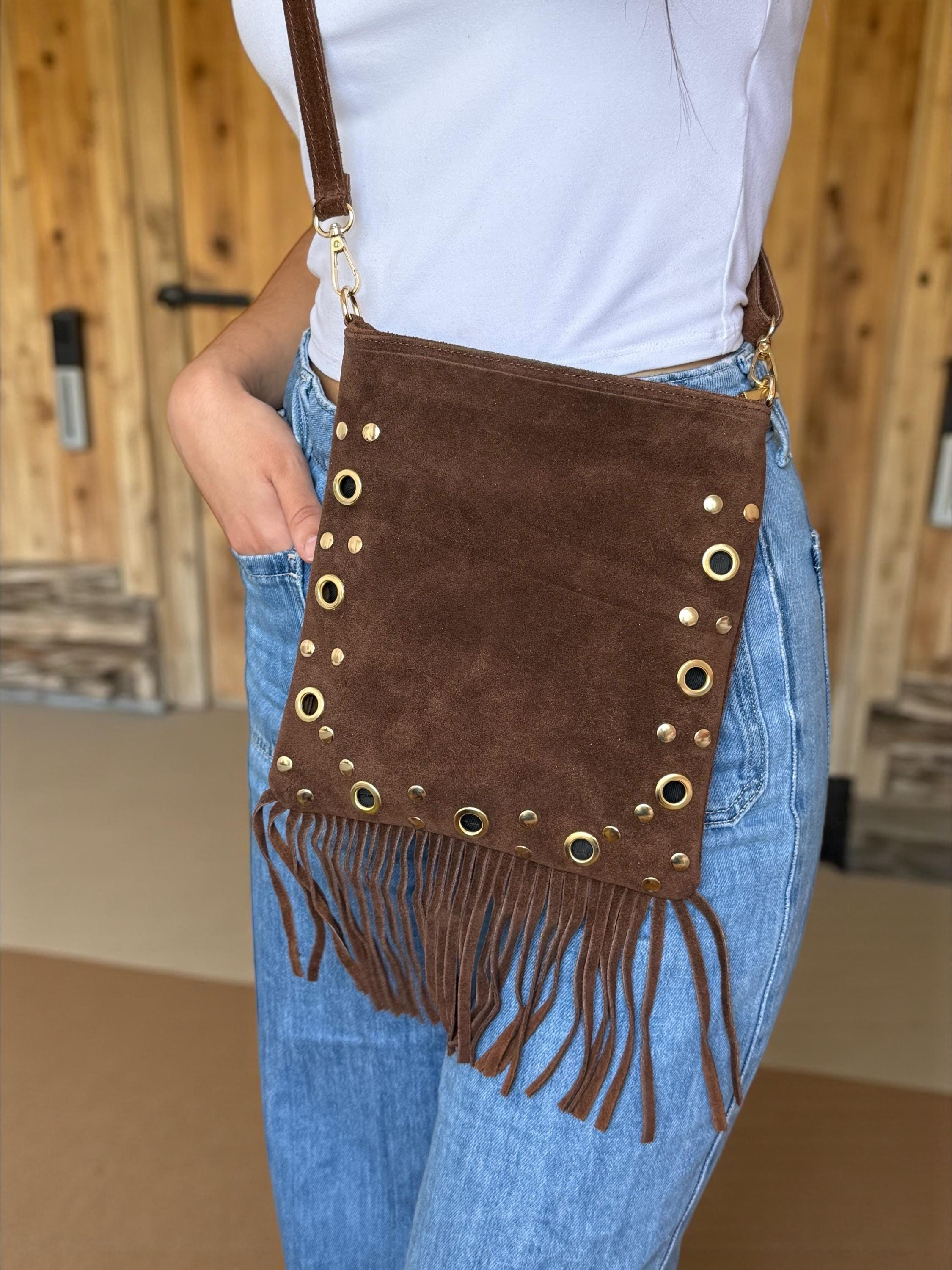 Woman wearing a small suede fringe bag for a festival or weekend